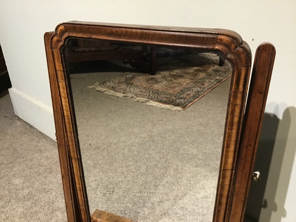A Georgian walnut toilet mirror featuring a rectangular tilting glass frame supported by upright posts over a base with two small drawers and brass knobs. View IV