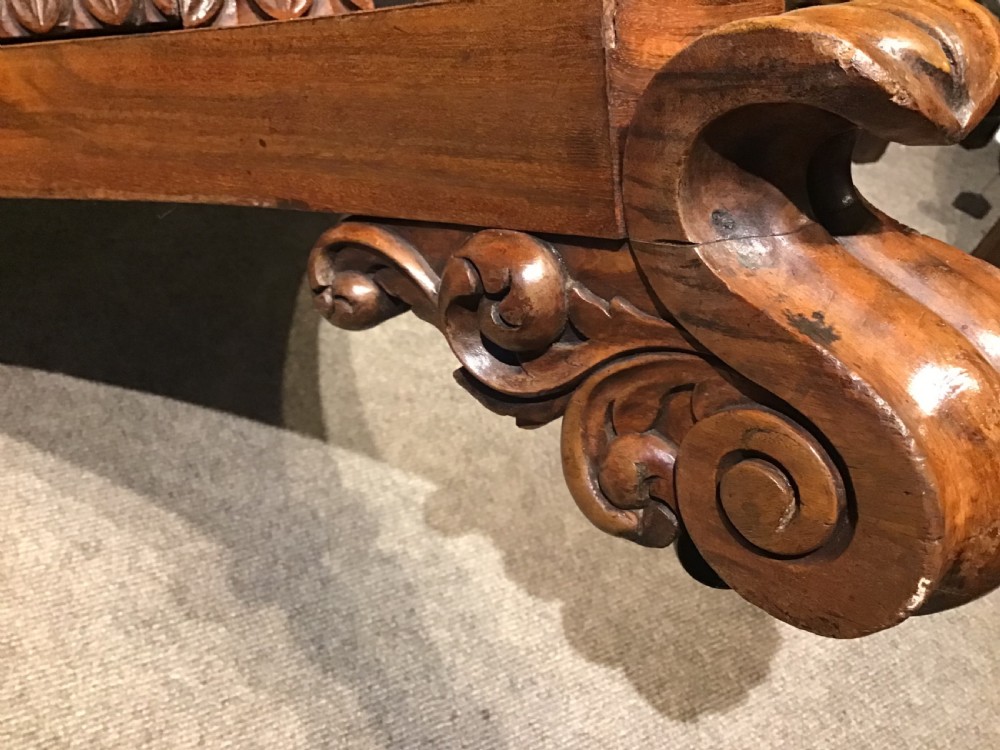 A circular William IV Goncalo Alves tilt-top centre table tilted vertically to show the figured timber grain above a triform base with carved scroll feet. View VII