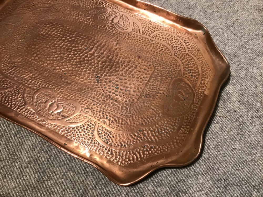 A rectangular hand-hammered copper tray featuring a planished surface, shaped rims, and stylised floral motifs. View II