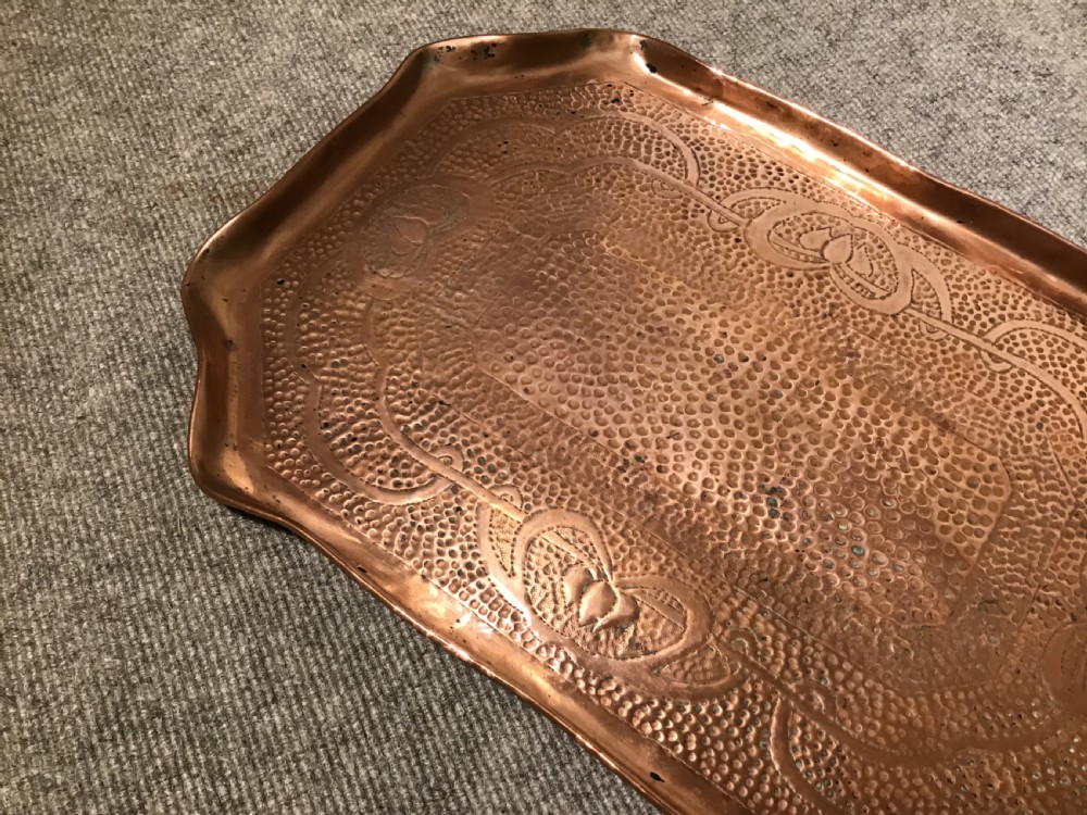 A rectangular hand-hammered copper tray featuring a planished surface, shaped rims, and stylised floral motifs. View III
