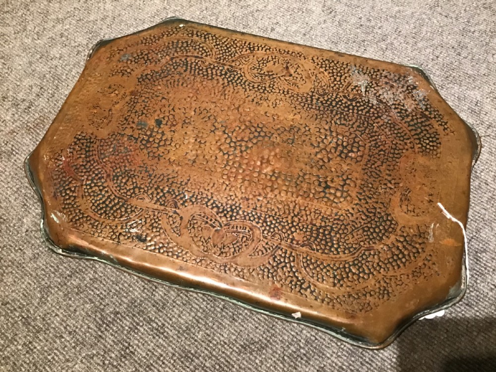 A rectangular hand-hammered copper tray featuring a planished surface, shaped rims, and stylised floral motifs. View IV