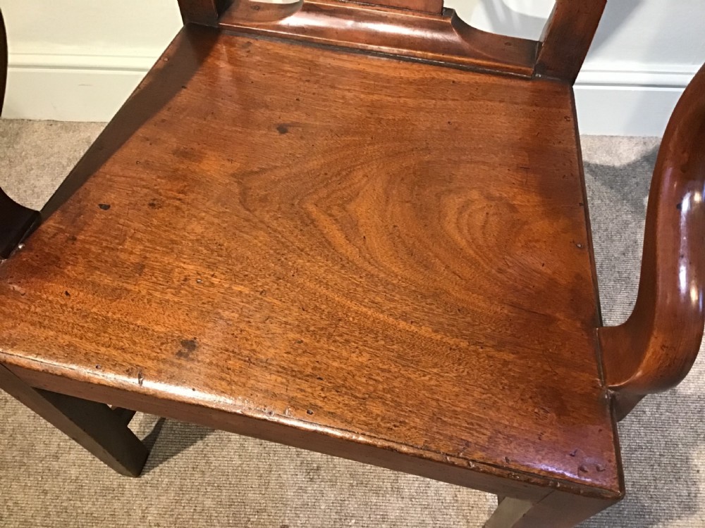 A Georgian mahogany elbow chair featuring a pierced urn-shaped splat back, swept open arms, and square legs supported by H-stretchers. View VII