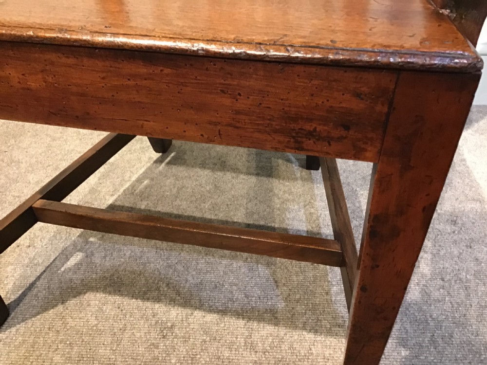 A Georgian mahogany elbow chair featuring a pierced urn-shaped splat back, swept open arms, and square legs supported by H-stretchers. View VIII