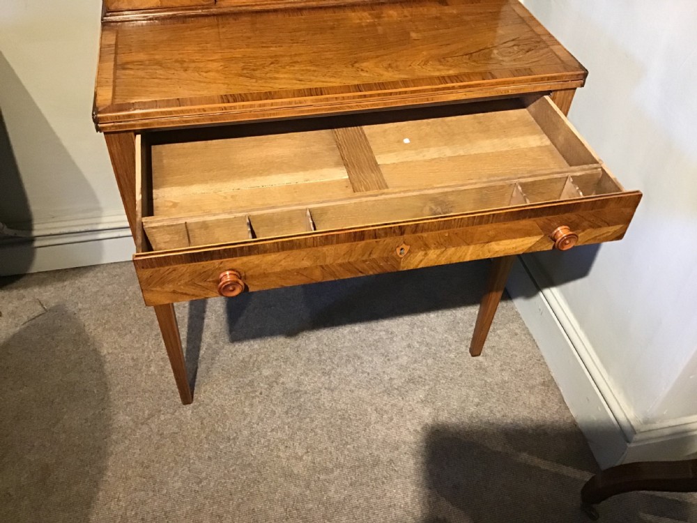 A rosewood bonheur du jour writing desk featuring geometric parquetry veneers, square tapered legs, a frieze drawer, and a raised cabinet top with brass fretwork rail. View III