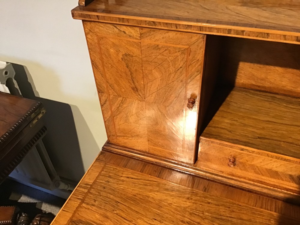 A rosewood bonheur du jour writing desk featuring geometric parquetry veneers, square tapered legs, a frieze drawer, and a raised cabinet top with brass fretwork rail. View VII