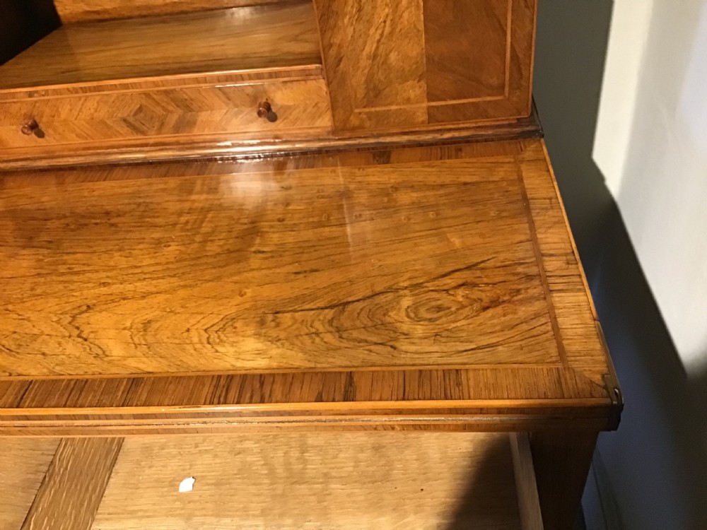 A rosewood bonheur du jour writing desk featuring geometric parquetry veneers, square tapered legs, a frieze drawer, and a raised cabinet top with brass fretwork rail. View IX