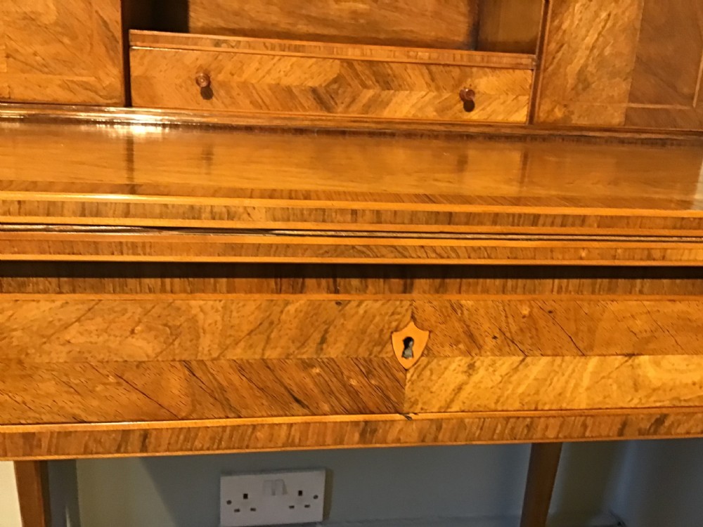 A rosewood bonheur du jour writing desk featuring geometric parquetry veneers, square tapered legs, a frieze drawer, and a raised cabinet top with brass fretwork rail. View X