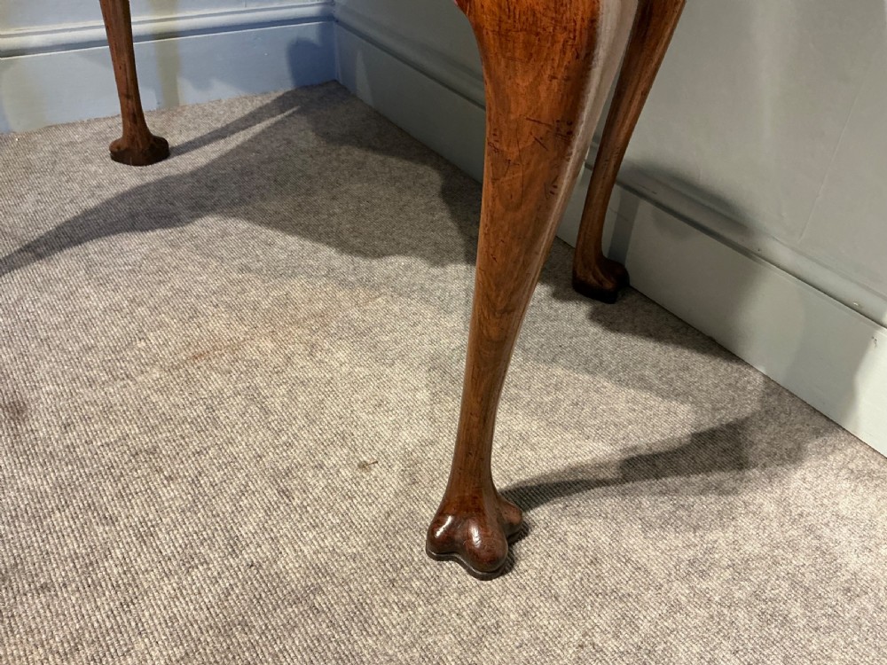 A Georgian walnut lowboy featuring three drawers with brass handles, a crossbanded veneered top, a shaped apron, and four cabriole legs with pad feet. View VI