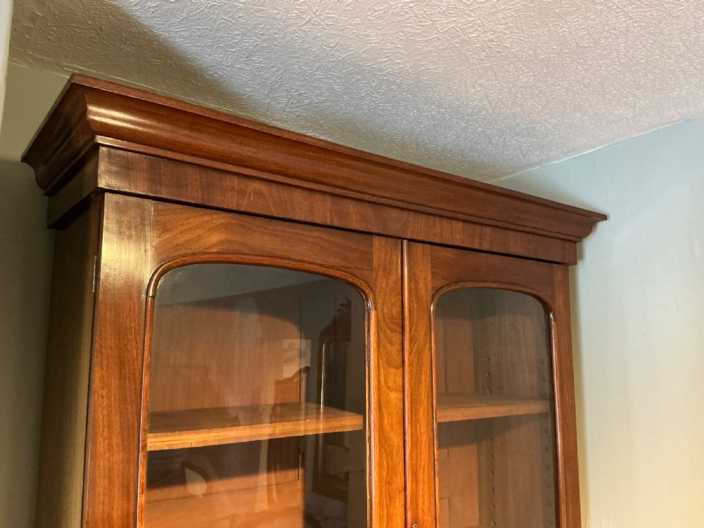 A Victorian mahogany secretaire bookcase featuring an upper glazed two-door cabinet, a central secretaire drawer with turned wooden handles, and a lower double-door cupboard. View IV