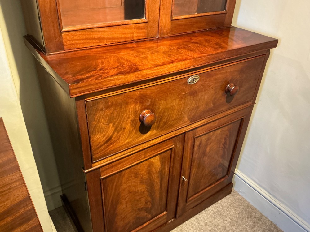 A Victorian mahogany secretaire bookcase featuring an upper glazed two-door cabinet, a central secretaire drawer with turned wooden handles, and a lower double-door cupboard. View VII