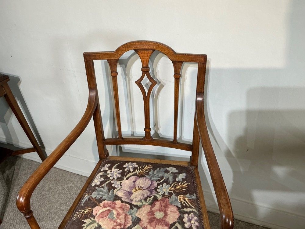 An Edwardian mahogany elbow chair featuring a slatted backrest with central diamond inlay, swept arms, tapered square legs, and a floral needlepoint upholstered seat. View II