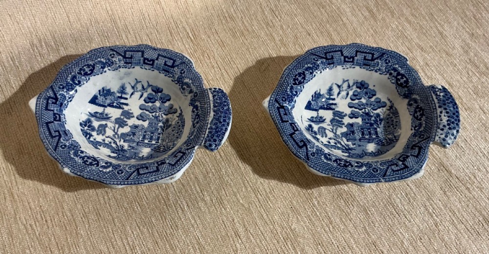 A pair of small, leaf-shaped blue and white ceramic pickle dishes decorated in the traditional Willow transferware pattern.