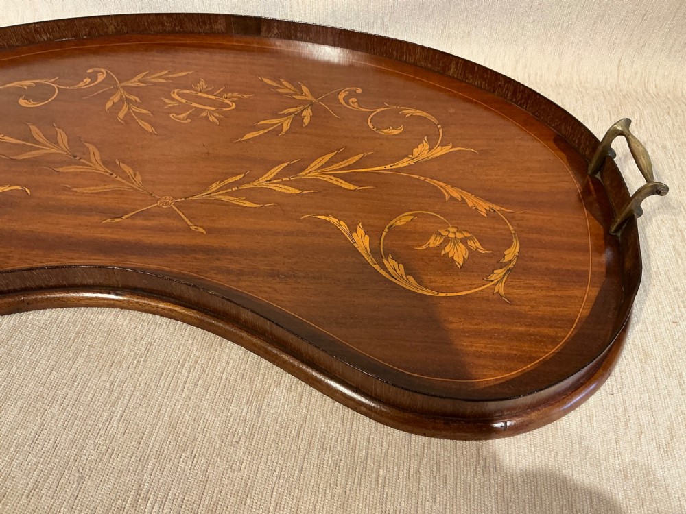 A kidney-shaped mahogany tray featuring inlaid satinwood leaf scrolls and a central urn motif, complete with twin brass handles and a raised gallery edge. View III