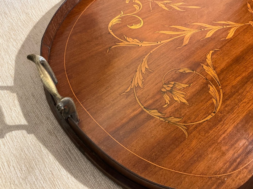 A kidney-shaped mahogany tray featuring inlaid satinwood leaf scrolls and a central urn motif, complete with twin brass handles and a raised gallery edge. View V