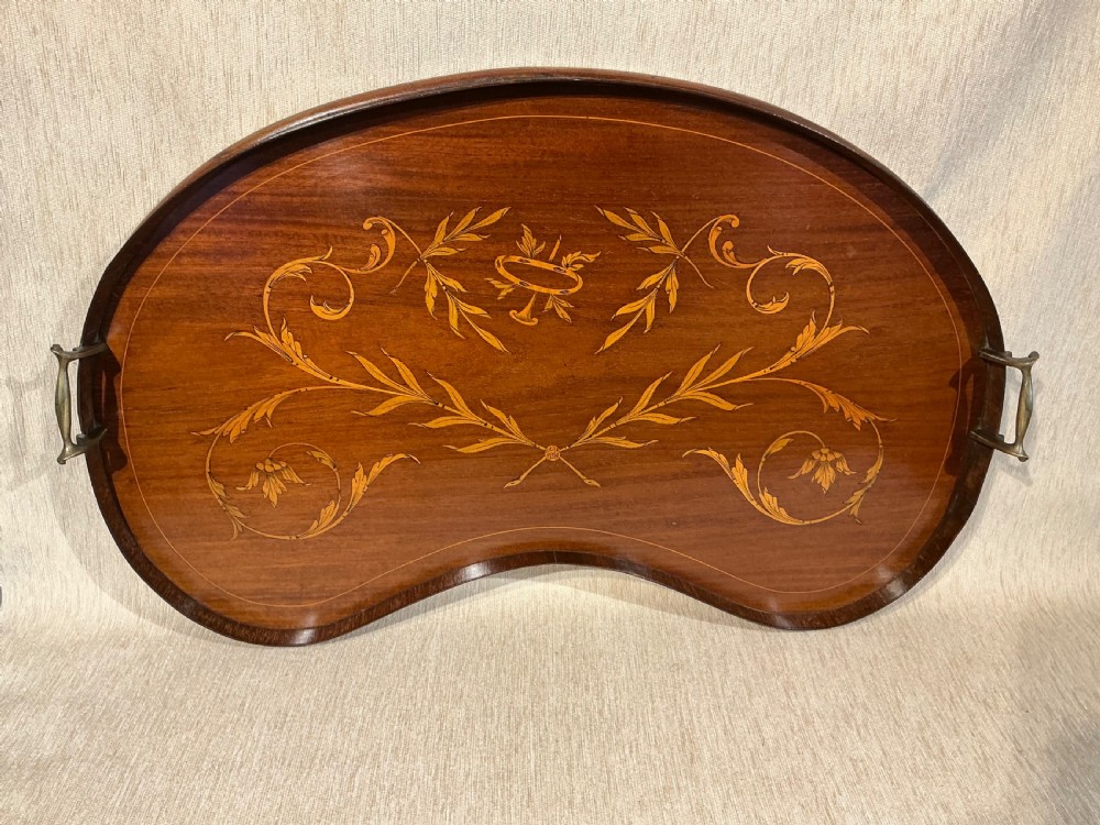 A kidney-shaped mahogany tray featuring inlaid satinwood leaf scrolls and a central urn motif, complete with twin brass handles and a raised gallery edge. View VI