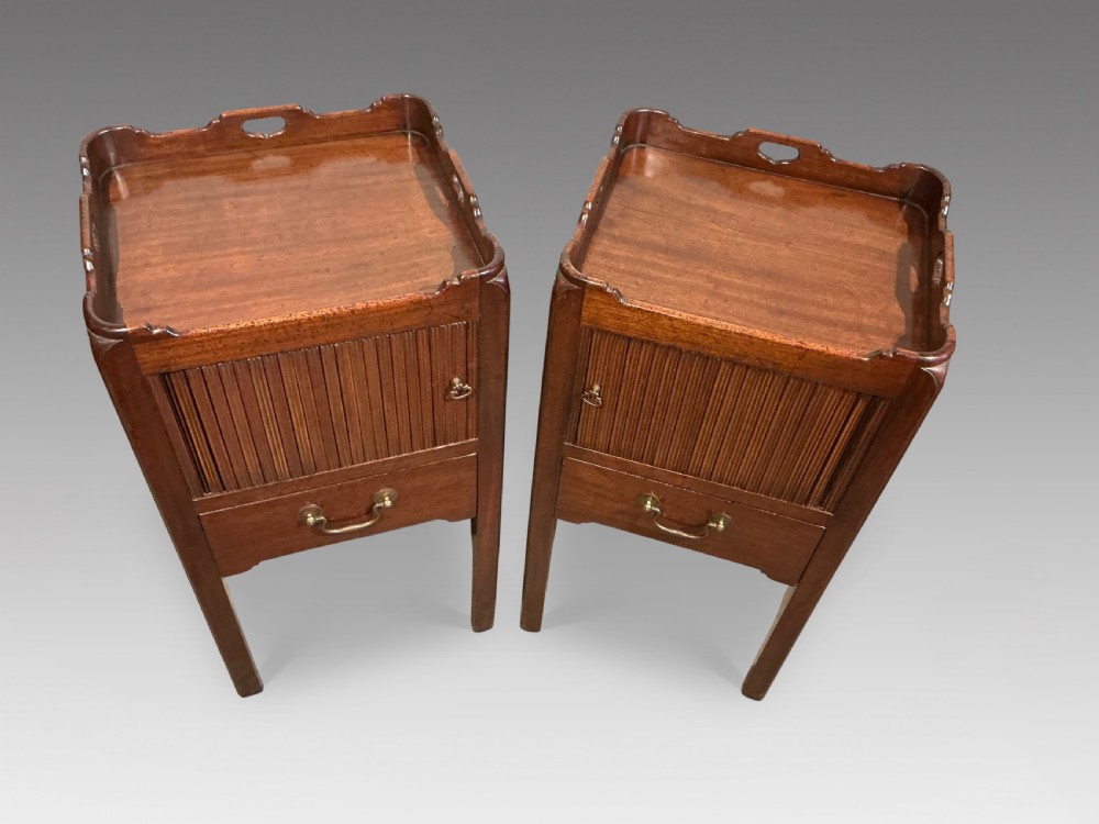 A pair of antique dark mahogany bedside cabinets featuring tray tops with carved handles, slatted tambour sliding doors, single drawers with brass handles, and square legs. View II