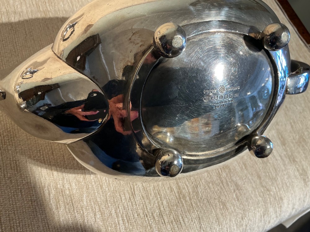 A four-piece antique silver-plated tea service comprising a teapot, coffee pot, sugar bowl, and milk jug with carved dark wood handles and ball feet. View IX