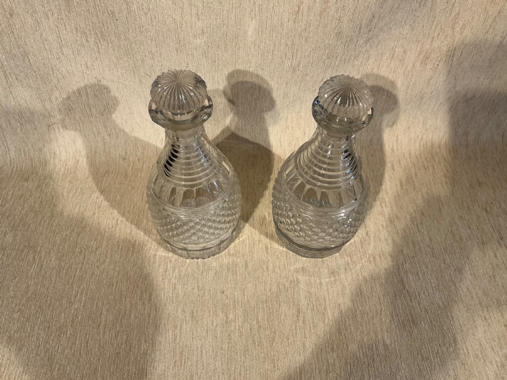A pair of late Georgian clear cut-glass decanters featuring stepped neck rings, diamond pattern bands, and flat mushroom stoppers. View III