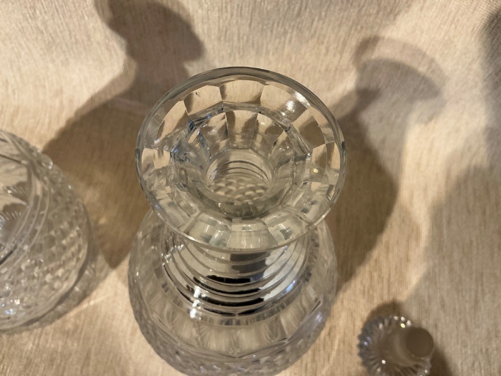 A pair of late Georgian clear cut-glass decanters featuring stepped neck rings, diamond pattern bands, and flat mushroom stoppers. View IV