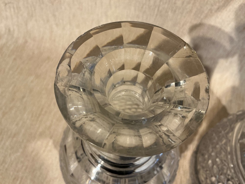 A pair of late Georgian clear cut-glass decanters featuring stepped neck rings, diamond pattern bands, and flat mushroom stoppers. View VII