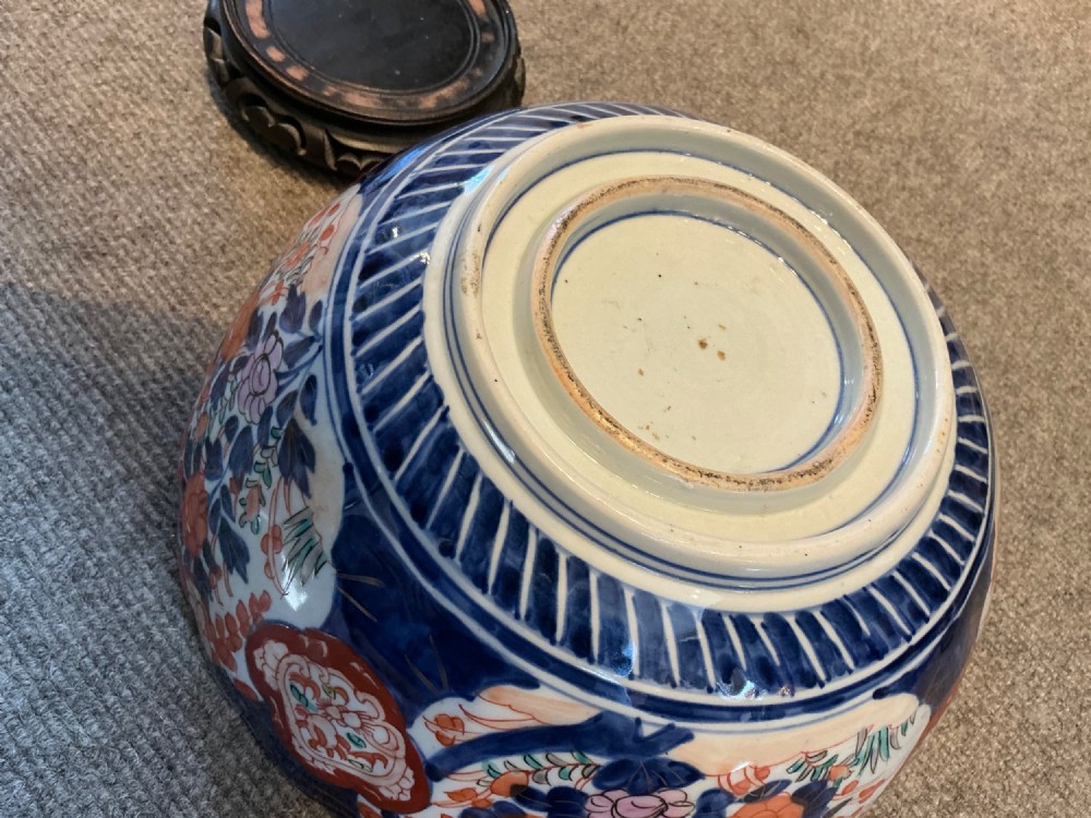 A large hand-painted Japanese Imari porcelain bowl featuring a scalloped lobed rim, floral panels, and underglaze cobalt blue and iron red patterns. View VII