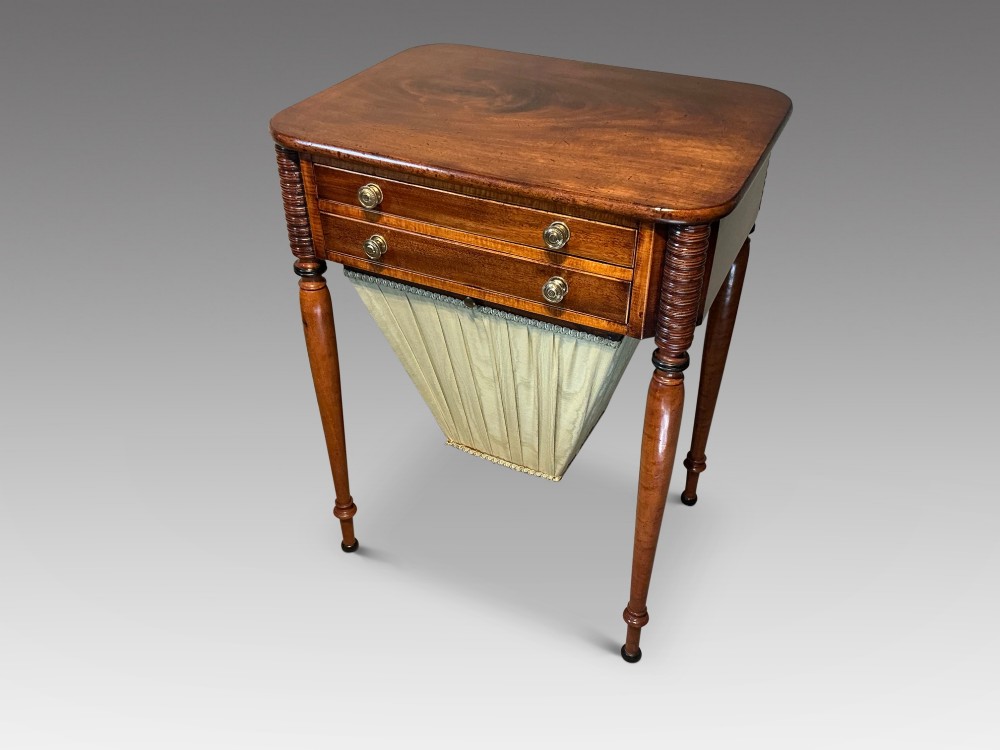 An early nineteenth-century mahogany and maple work table featuring two drawers with brass knobs, reeded upper corner detailing, and turned legs. View II