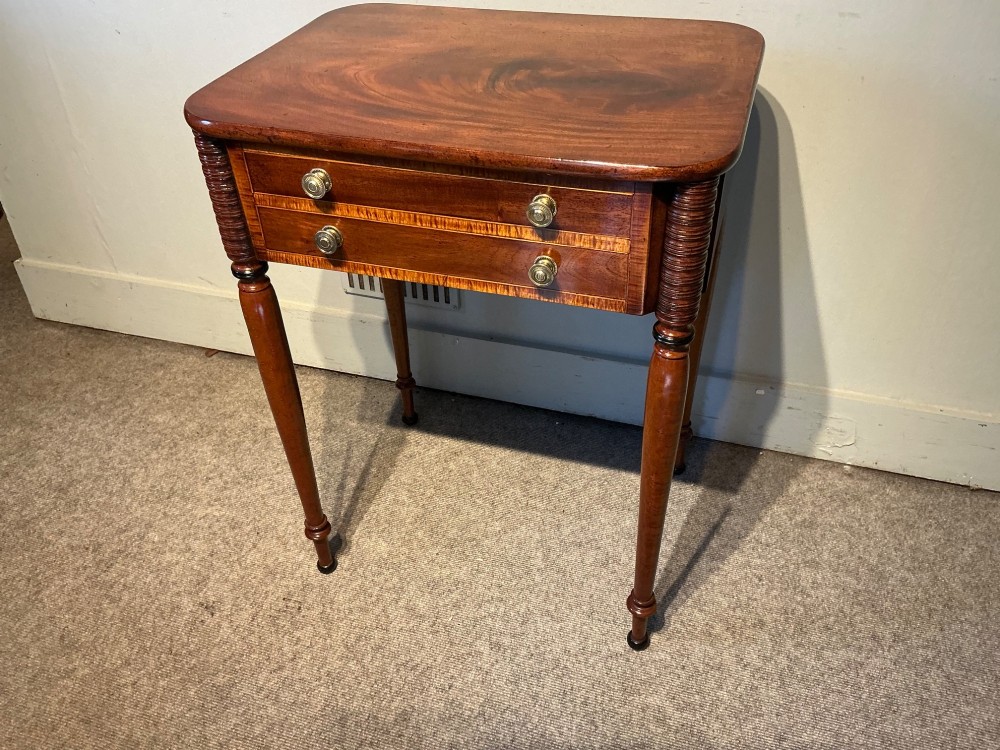 An early nineteenth-century mahogany and maple work table featuring two drawers with brass knobs, reeded upper corner detailing, and turned legs. View VII