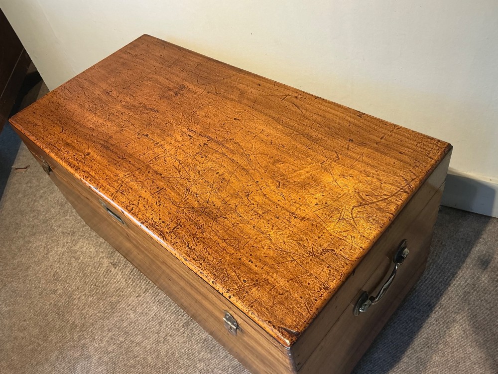 A rectangular antique camphorwood trunk with recessed metal handles and front latches. View IV