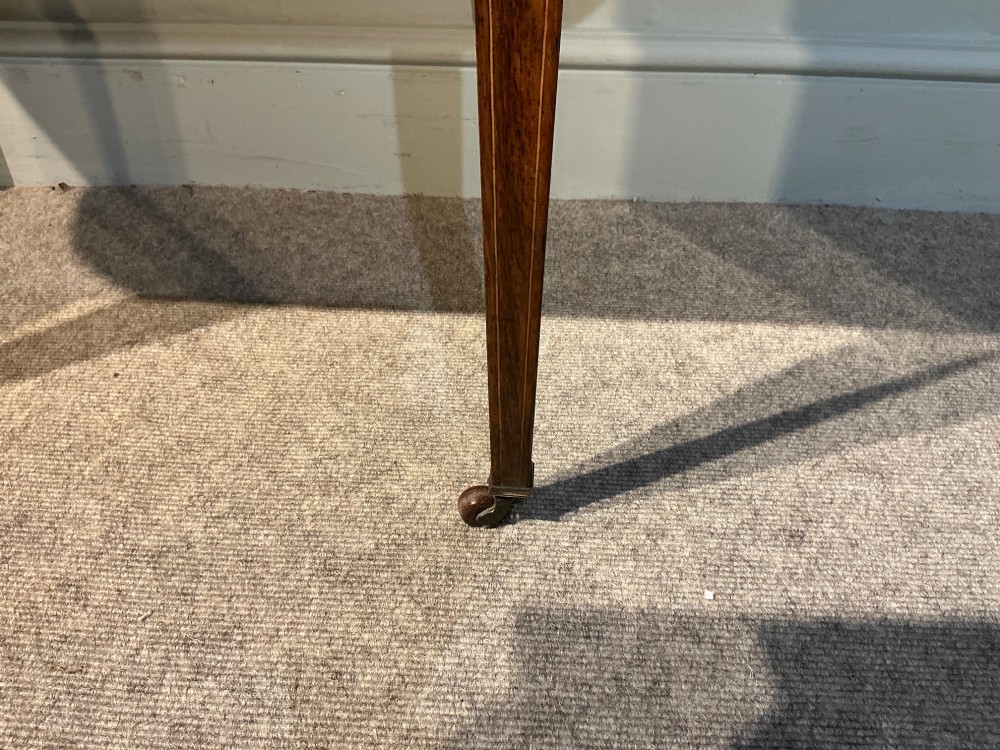 An antique inlaid rosewood writing table featuring a dark leather inset surface, classical urn marquetry, a single drawer, and square tapered legs on brass castors. View IX