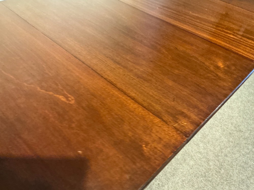 A mahogany twin pedestal dining table featuring rounded rectangular top corners, splayed tripod legs, and brass castors. View IX