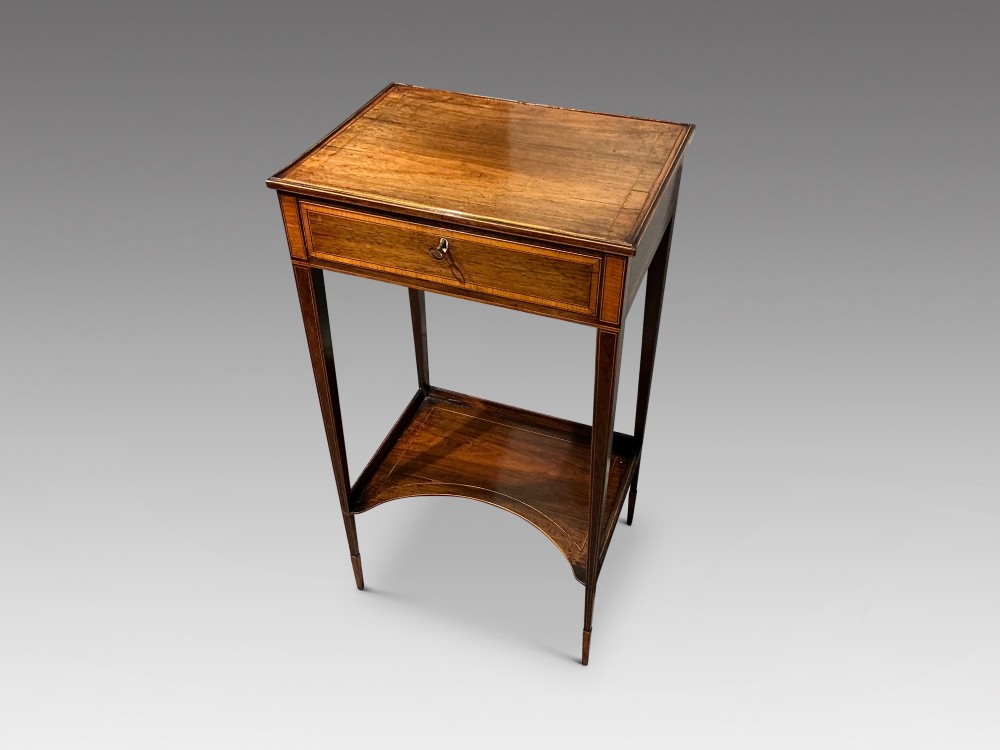 A late Georgian Sheraton mahogany work table featuring satinwood crossbanding, a single drawer, tapered square legs, and a concave lower undertier. View III
