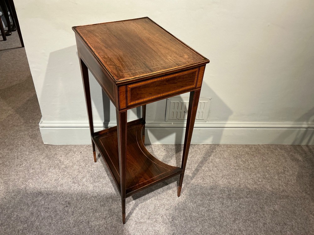 A late Georgian Sheraton mahogany work table featuring satinwood crossbanding, a single drawer, tapered square legs, and a concave lower undertier. View VI