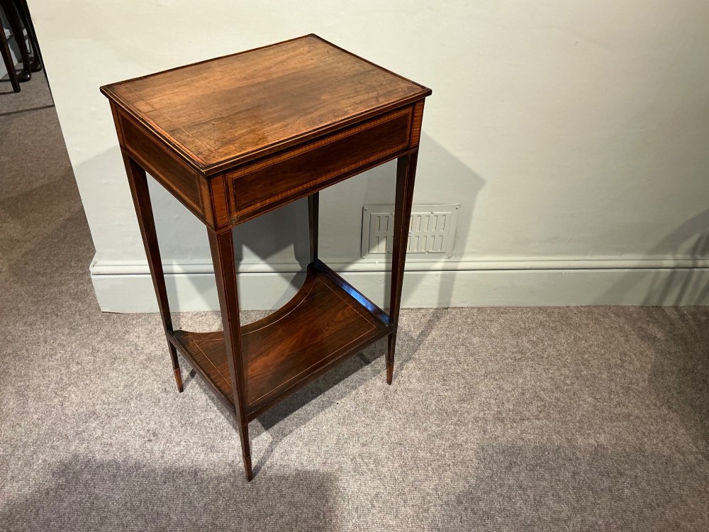 A late Georgian Sheraton mahogany work table featuring satinwood crossbanding, a single drawer, tapered square legs, and a concave lower undertier. View VII