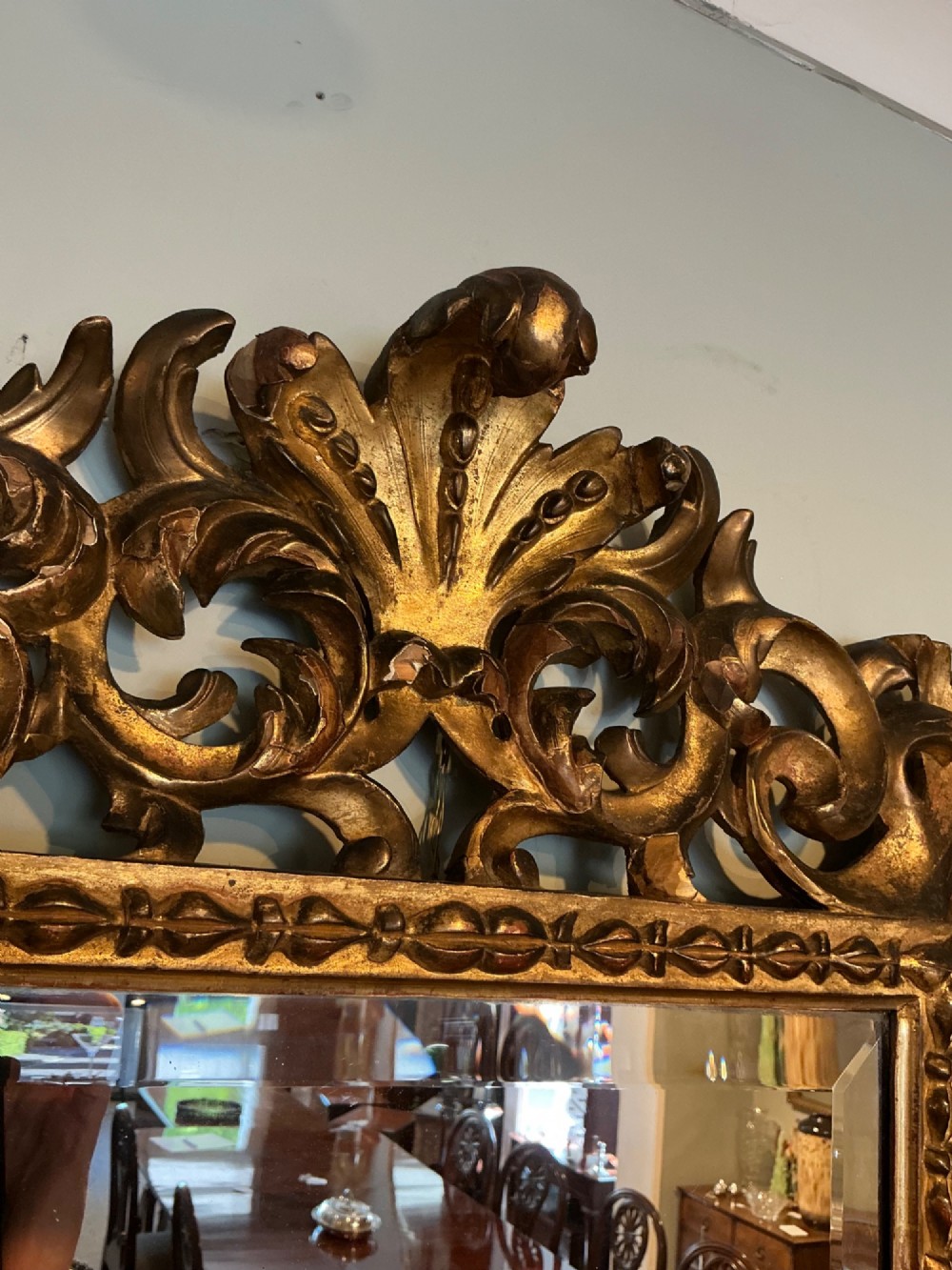 A rectangular antique wall mirror featuring a heavily carved and pierced giltwood frame decorated with acanthus leaf motifs and scrollwork. View VI