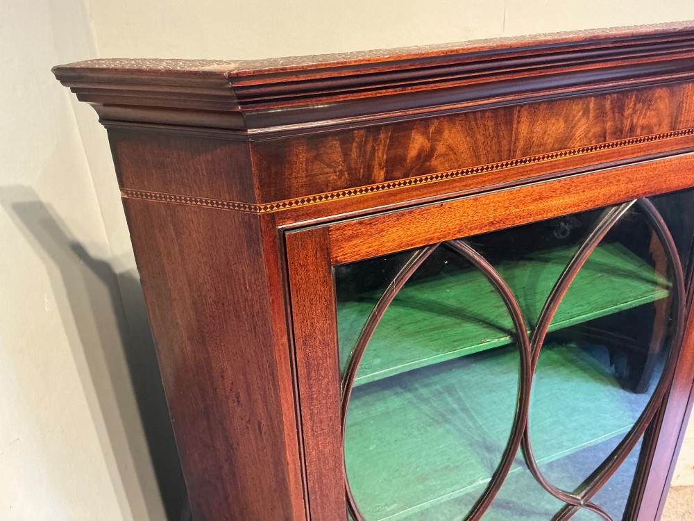 A Georgian mahogany wall-hanging corner cabinet featuring a moulded cornice and a single glass door with geometric oval astragal glazing bars. View V