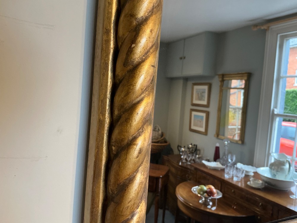 A horizontal Regency giltwood overmantel mirror featuring an anthemion frieze across the top and spiral-twist side columns. View IV