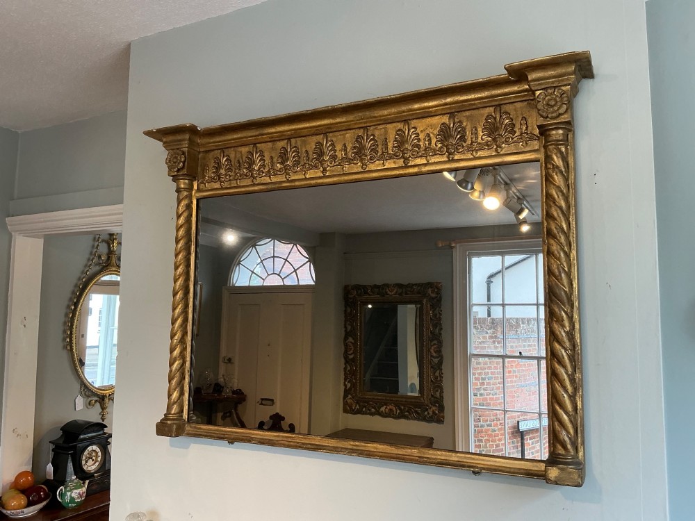 A horizontal Regency giltwood overmantel mirror featuring an anthemion frieze across the top and spiral-twist side columns. View VI