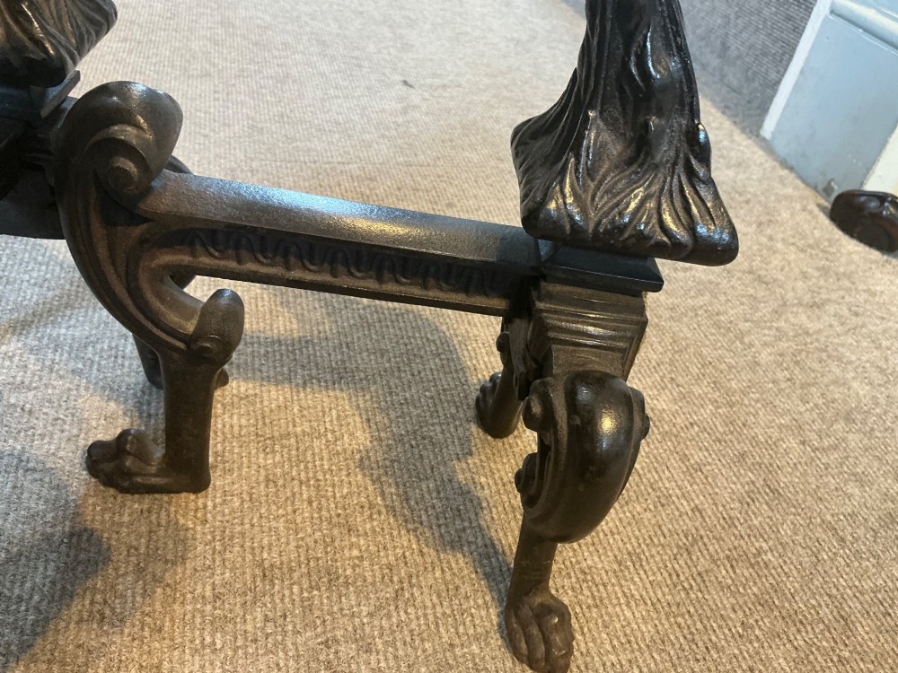 A pair of antique cast iron and brass andirons featuring spherical brass finials, lion mask central motifs, scrolled legs, and claw feet. View IV