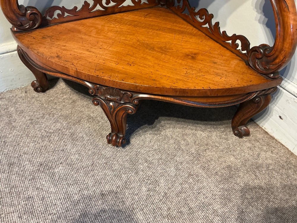A three-tier antique corner whatnot in warm brown polished wood, featuring pierced fretwork galleries, serpentine supports, and carved feet. View V