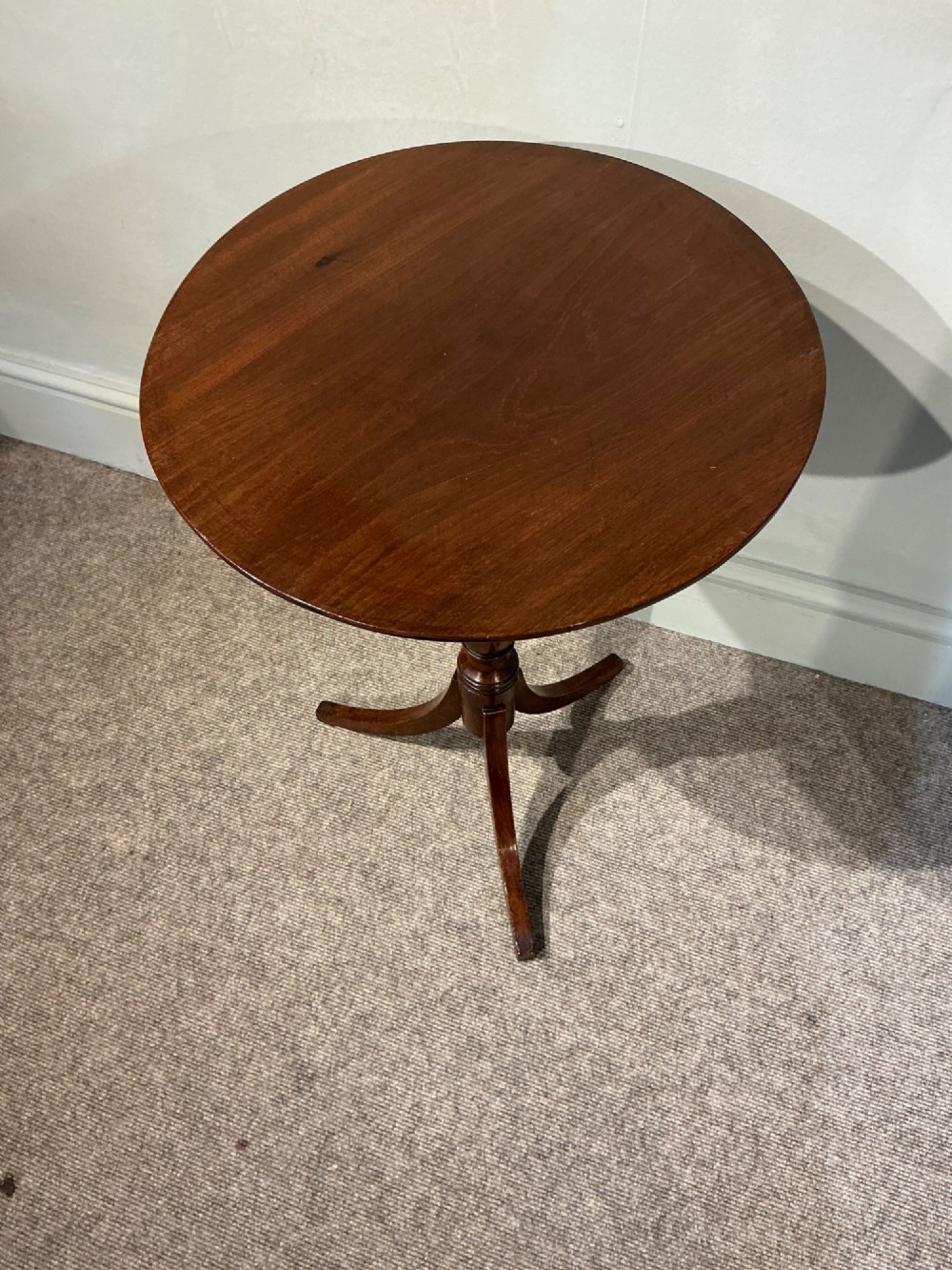 An antique dark mahogany wine table featuring a circular top supported by a turned central column on a tripod base. View III
