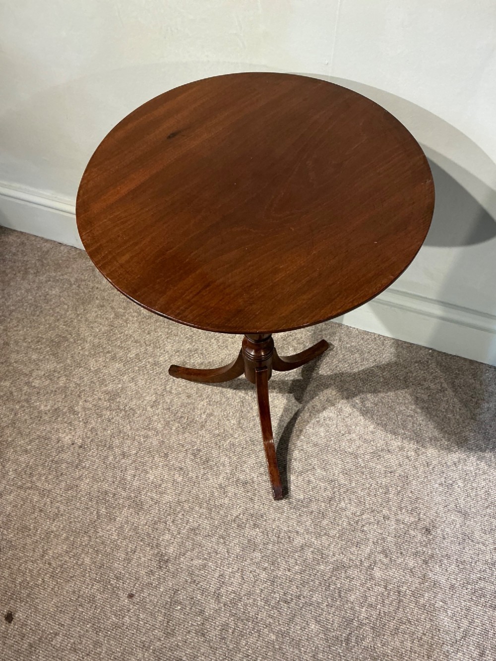 An antique dark mahogany wine table featuring a circular top supported by a turned central column on a tripod base. View IV