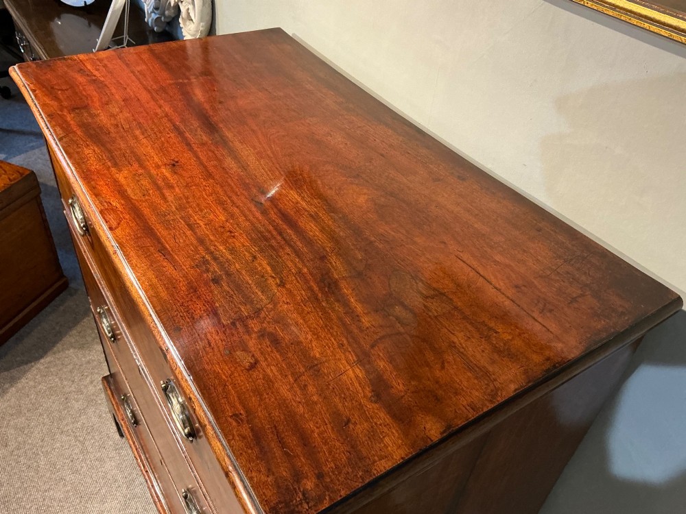 A Georgian mahogany chest of drawers with three graduated drawers, oval brass drop handles, and bracket feet. View II