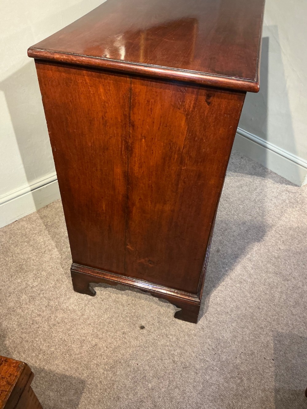 A Georgian mahogany chest of drawers with three graduated drawers, oval brass drop handles, and bracket feet. View VIII
