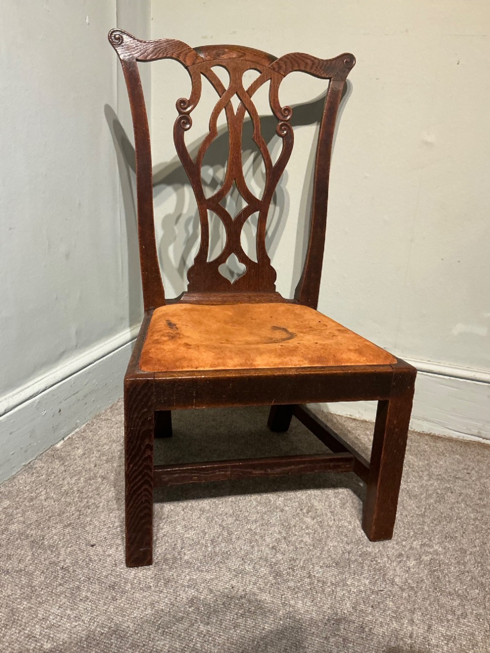 An antique dark oak side chair with an intricate pierced scroll splat back and a light brown upholstered drop-in seat. View II