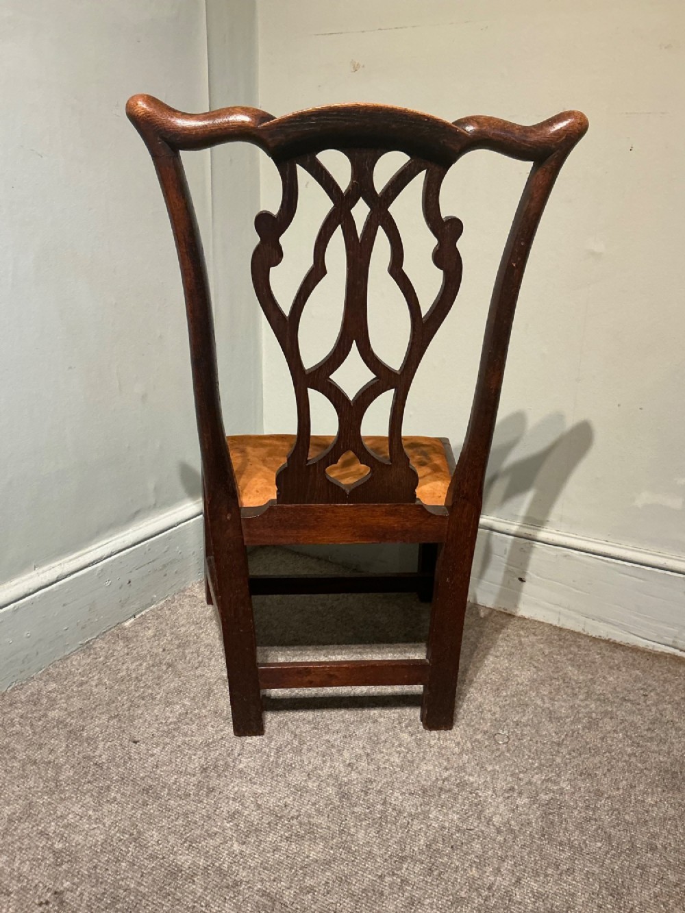 An antique dark oak side chair with an intricate pierced scroll splat back and a light brown upholstered drop-in seat. View VII