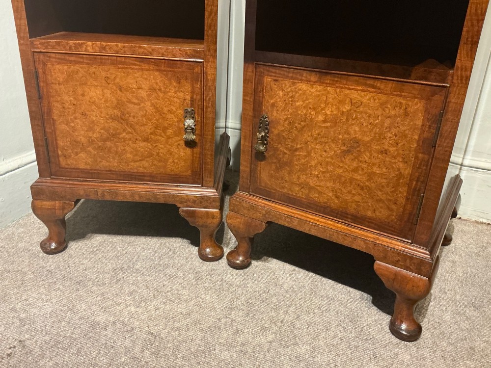 A matching pair of burr walnut bedside cabinets featuring pull-out slides, single drawers, open cubbies, lower cupboard doors, and cabriole legs. View IV