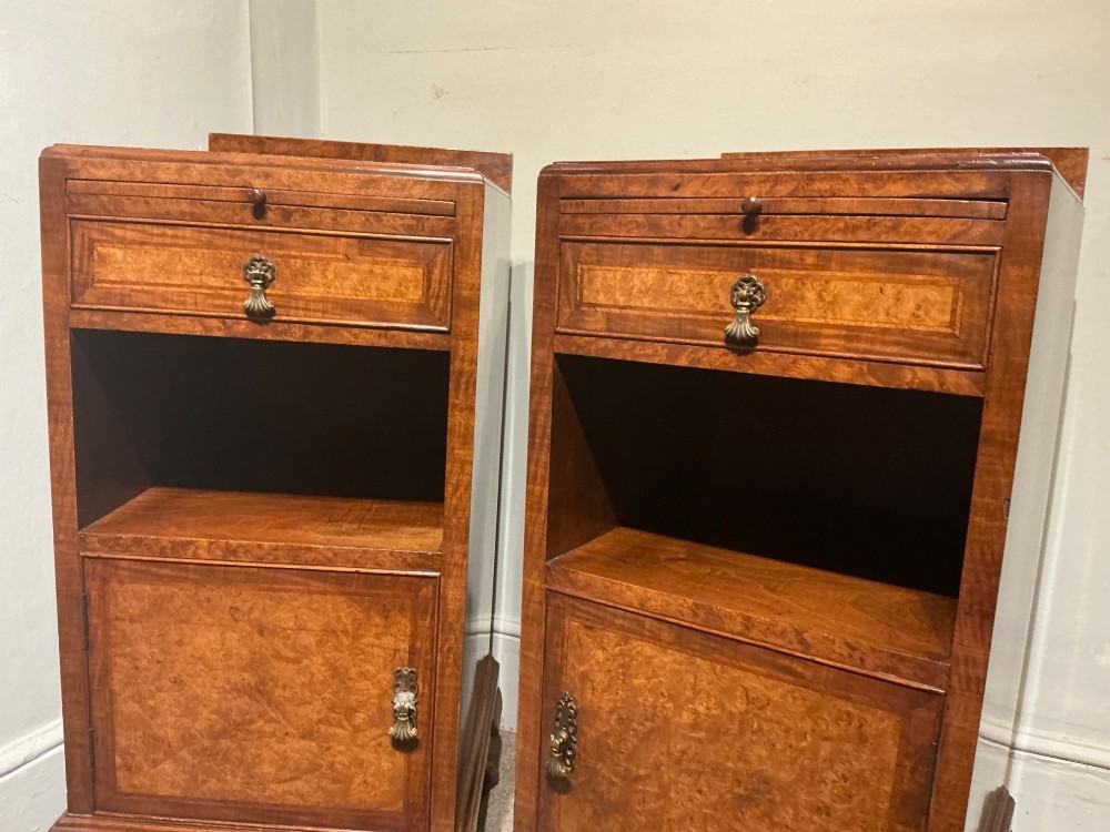 A matching pair of burr walnut bedside cabinets featuring pull-out slides, single drawers, open cubbies, lower cupboard doors, and cabriole legs. View V