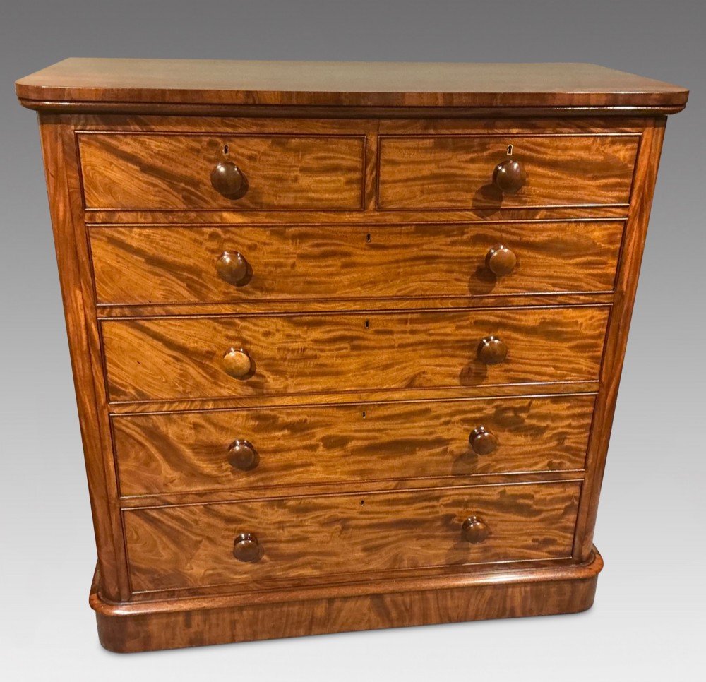 A Victorian mahogany chest of drawers featuring two short drawers over three long drawers with turned wooden knobs and flame veneer fronts. View II