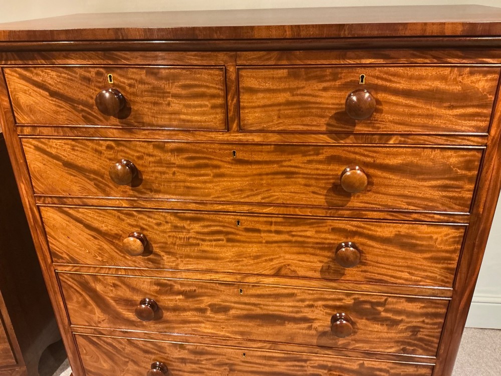 A Victorian mahogany chest of drawers featuring two short drawers over three long drawers with turned wooden knobs and flame veneer fronts. View IV