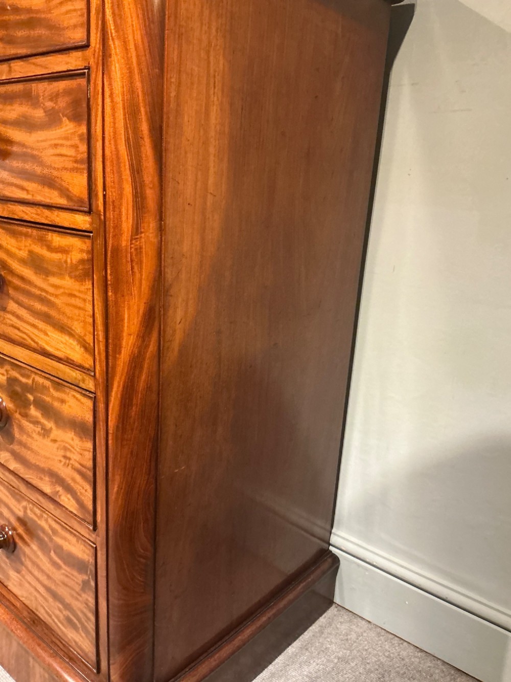A Victorian mahogany chest of drawers featuring two short drawers over three long drawers with turned wooden knobs and flame veneer fronts. View VII